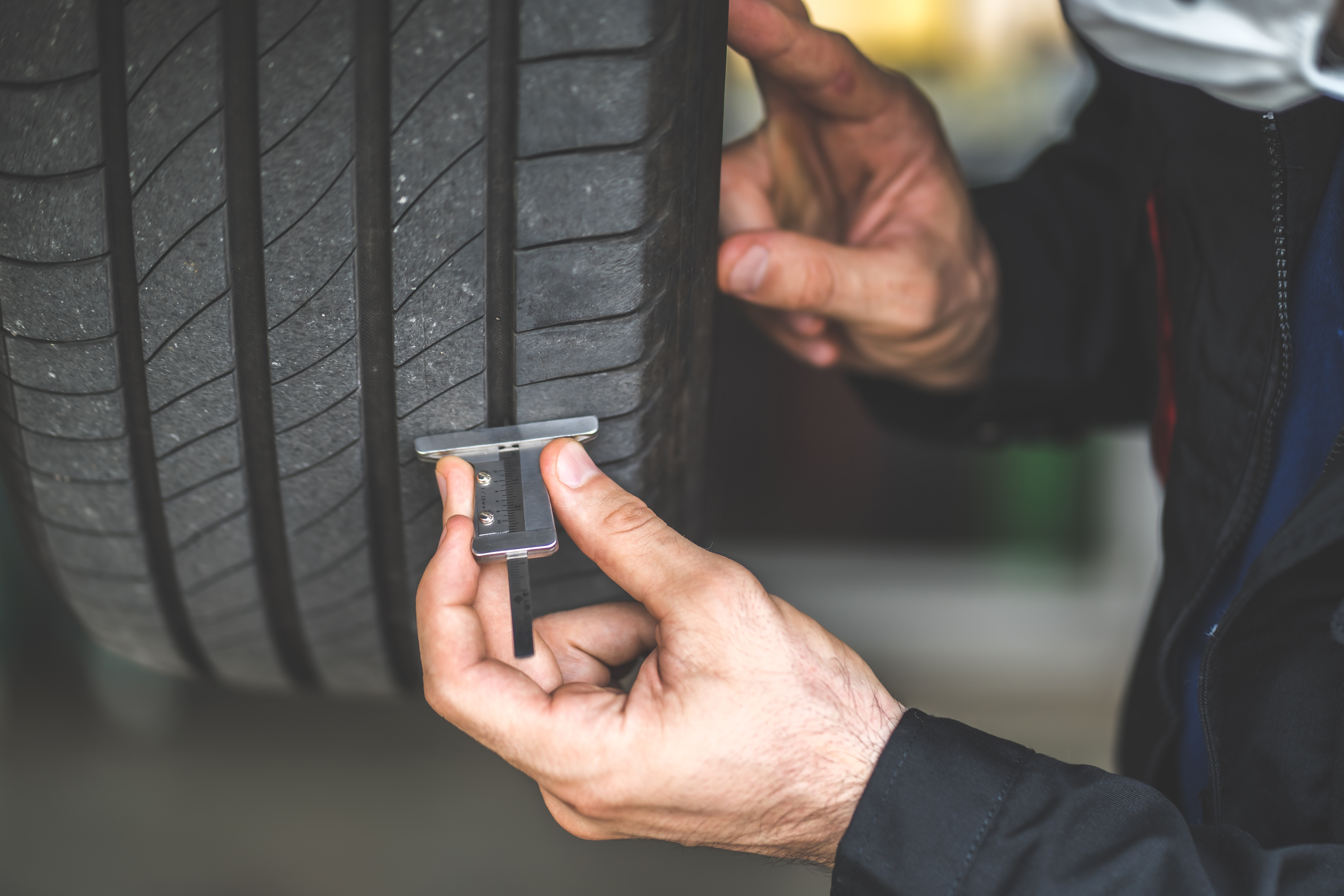 mechanic-checking-checking-depth-car-tire-tread-car-maintenance-auto-service-garage-concept (1).jpg